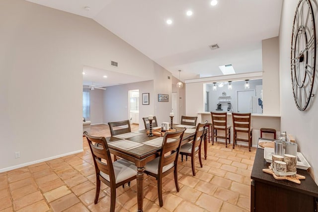 dining area featuring ceiling fan and vaulted ceiling with skylight