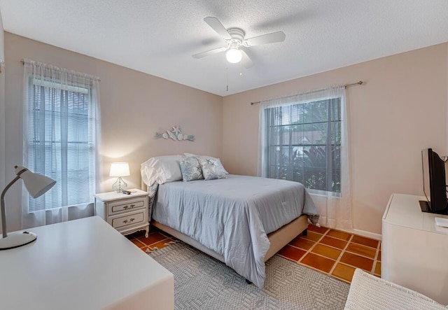 bedroom featuring ceiling fan, a textured ceiling, and tile patterned floors