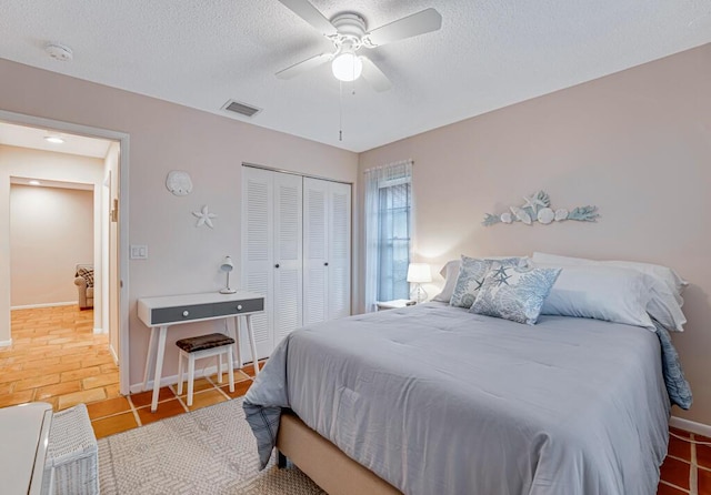 bedroom with ceiling fan, a closet, and tile patterned floors