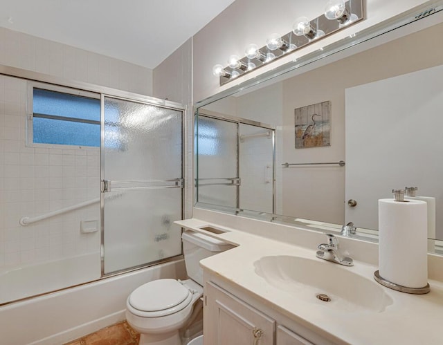 full bathroom featuring toilet, bath / shower combo with glass door, tile patterned flooring, and vanity