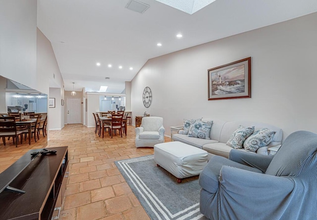 living room featuring vaulted ceiling with skylight