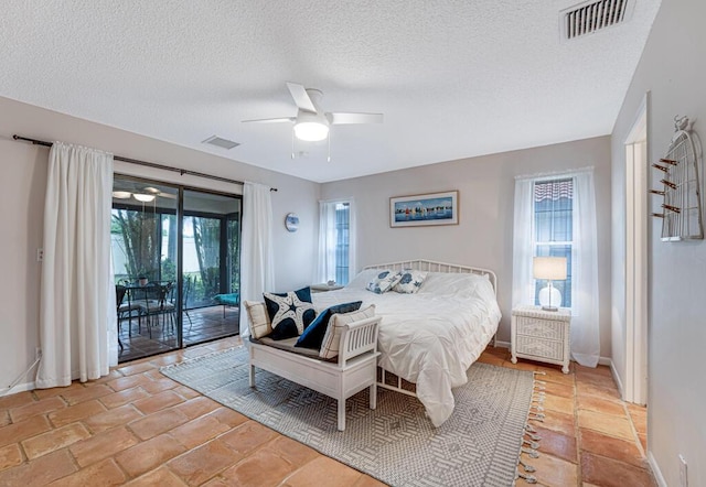 tiled bedroom featuring ceiling fan, access to exterior, and a textured ceiling