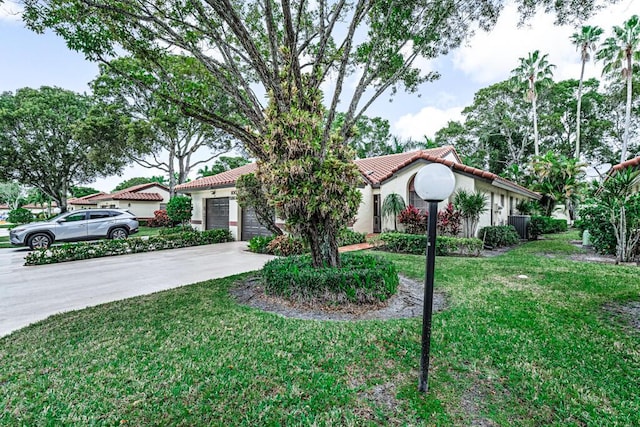 mediterranean / spanish-style house with a garage and a front lawn