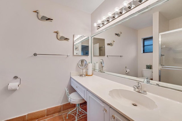 bathroom featuring toilet, tile patterned floors, a shower with shower door, and vanity