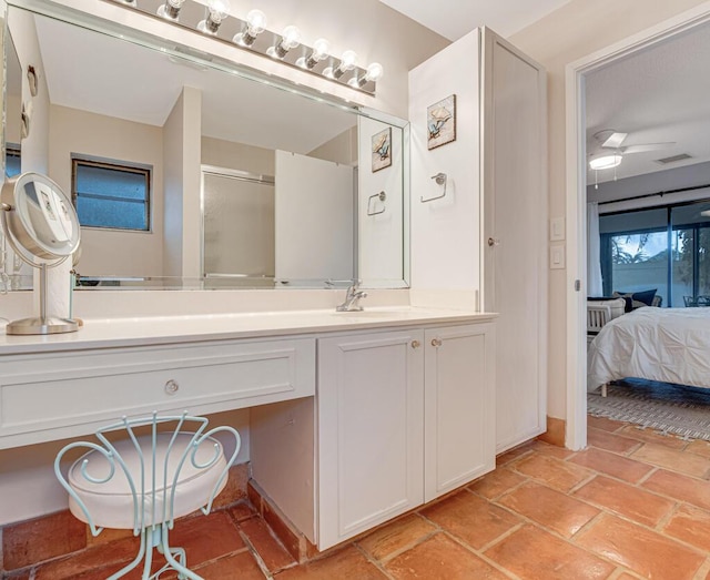 bathroom with ceiling fan, a shower with shower door, and vanity