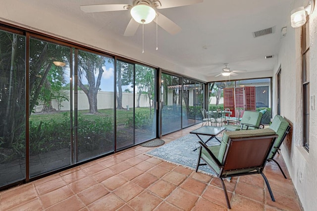 unfurnished sunroom with ceiling fan