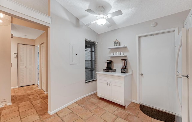 hall featuring vaulted ceiling, electric panel, and a textured ceiling