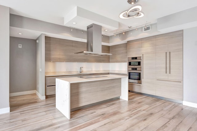 kitchen with light countertops, modern cabinets, visible vents, and island range hood