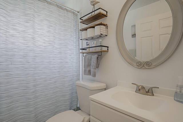 bathroom with toilet, vanity, and a shower with curtain