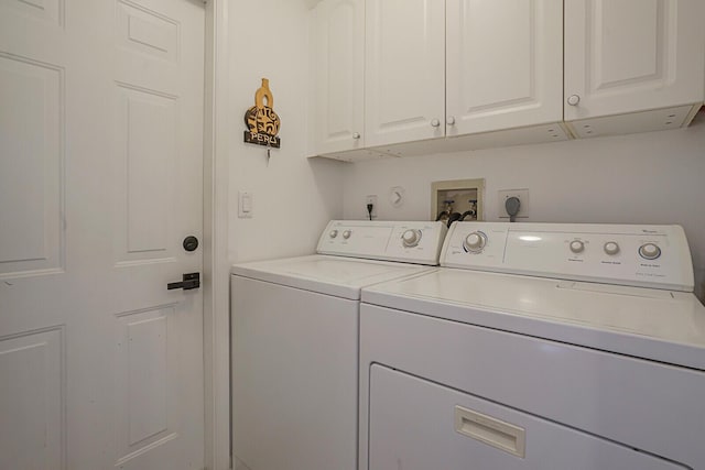 clothes washing area featuring cabinet space and washing machine and clothes dryer