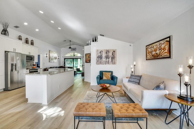 living room with lofted ceiling, light wood finished floors, visible vents, and recessed lighting