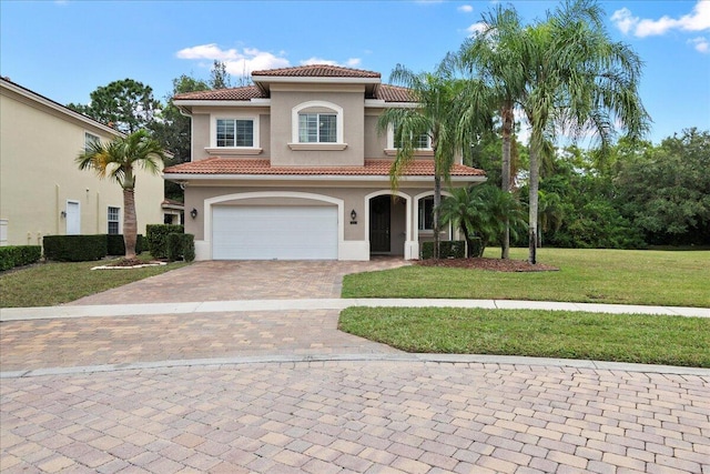 mediterranean / spanish house with a garage and a front yard