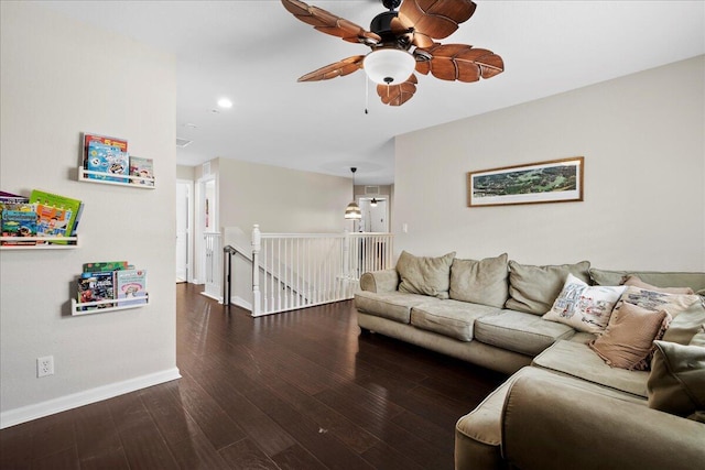 living room featuring dark wood-type flooring and ceiling fan