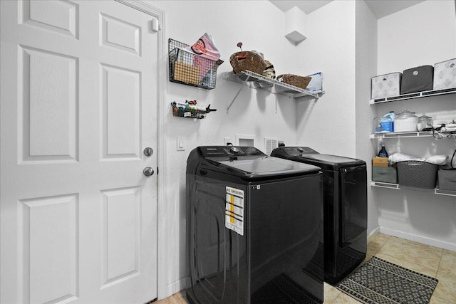 washroom with washing machine and dryer and light tile patterned floors