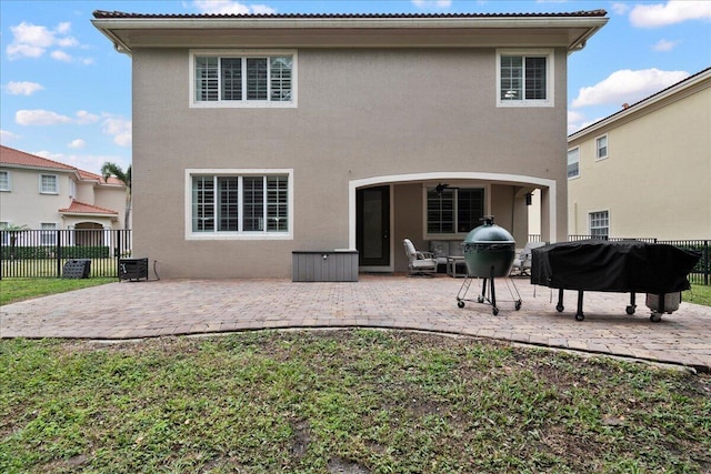 rear view of house with cooling unit, ceiling fan, and a patio area