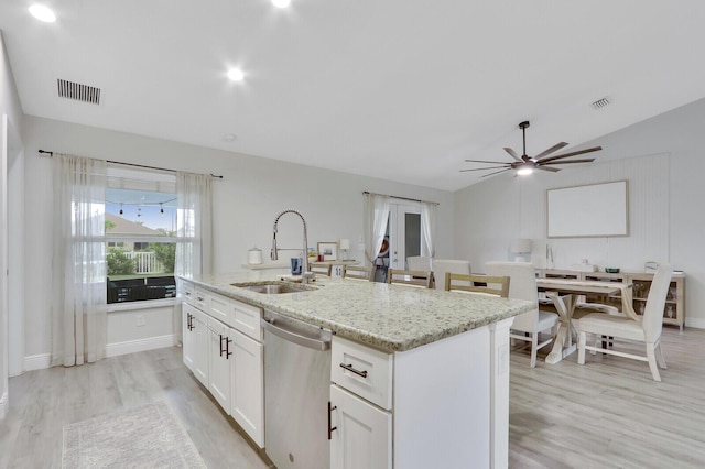 kitchen featuring white cabinets, a center island with sink, light stone countertops, sink, and stainless steel dishwasher