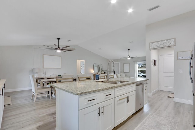 kitchen featuring dishwasher, an island with sink, light stone countertops, white cabinets, and sink