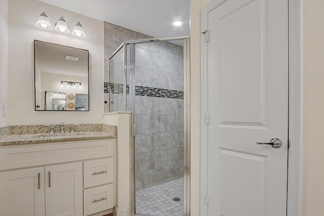 bathroom featuring vanity and a shower with shower door