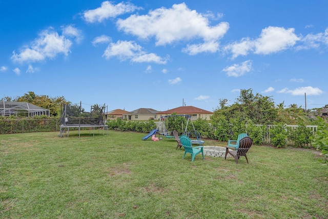 view of yard featuring a playground and a trampoline