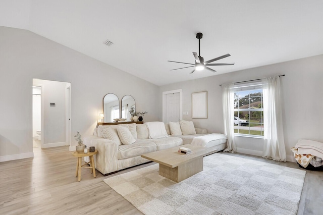 living room featuring lofted ceiling, ceiling fan, and light hardwood / wood-style floors