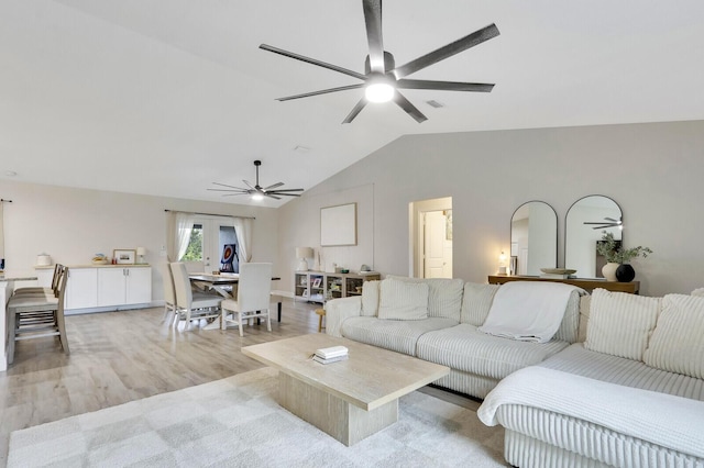 living room with vaulted ceiling and light hardwood / wood-style flooring