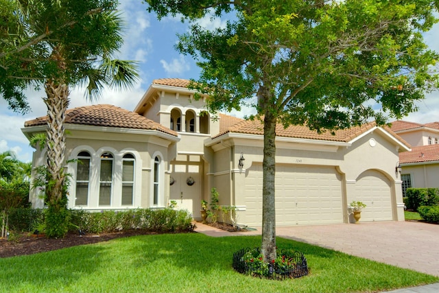 mediterranean / spanish-style home with a garage and a front yard