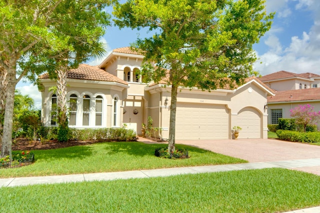 mediterranean / spanish-style home with a garage and a front lawn