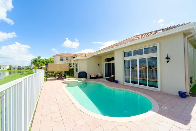 view of swimming pool with an in ground hot tub, a water view, and a patio area