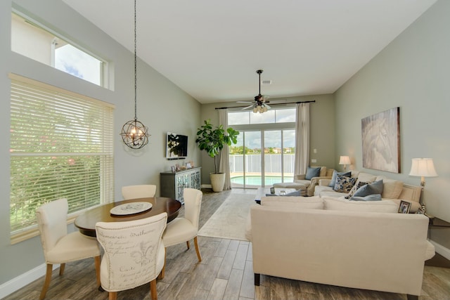 living room featuring ceiling fan with notable chandelier