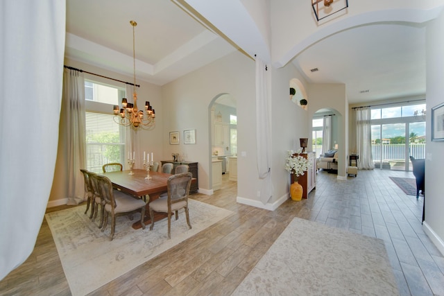 dining space featuring an inviting chandelier and a towering ceiling