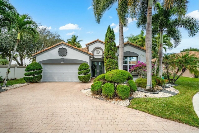 mediterranean / spanish-style house with a garage and french doors