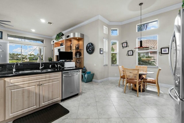 kitchen featuring sink, hanging light fixtures, appliances with stainless steel finishes, and crown molding