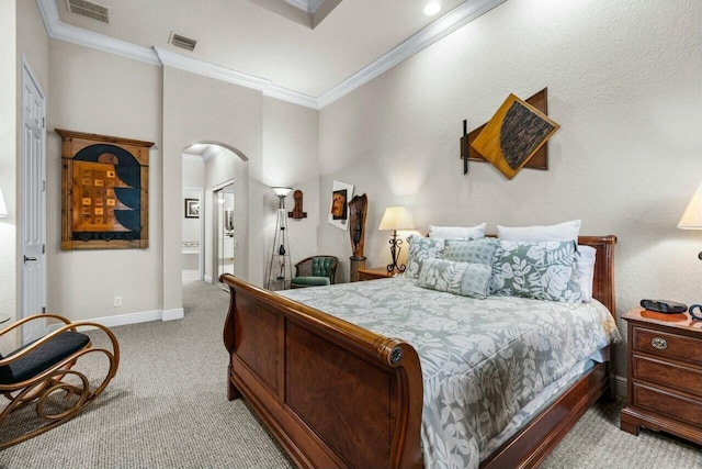 carpeted bedroom with ensuite bathroom and crown molding