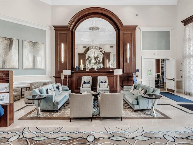 living room featuring a notable chandelier, a towering ceiling, and ornamental molding