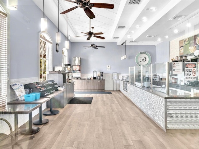 kitchen with pendant lighting, light hardwood / wood-style floors, and a high ceiling