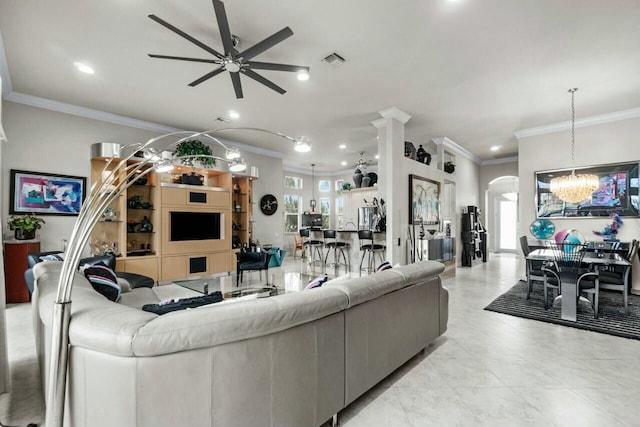 living room with ceiling fan with notable chandelier and crown molding