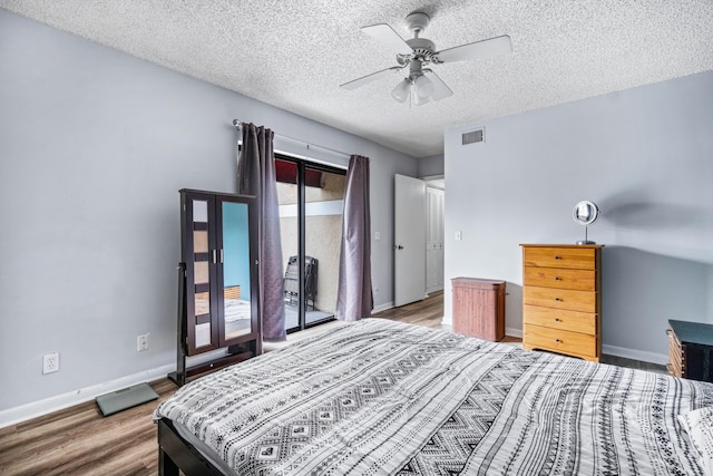 bedroom with ceiling fan, a textured ceiling, and hardwood / wood-style flooring