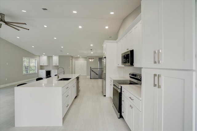 kitchen with sink, white cabinetry, a large island, and appliances with stainless steel finishes