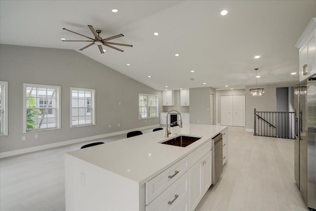 kitchen with appliances with stainless steel finishes, a spacious island, hanging light fixtures, sink, and white cabinets