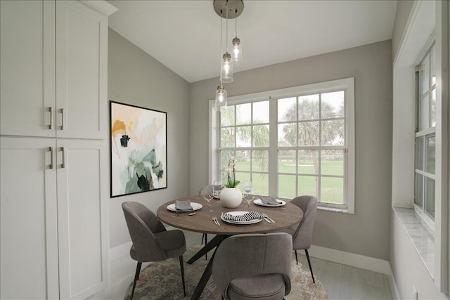 dining room with lofted ceiling, light hardwood / wood-style floors, and a wealth of natural light