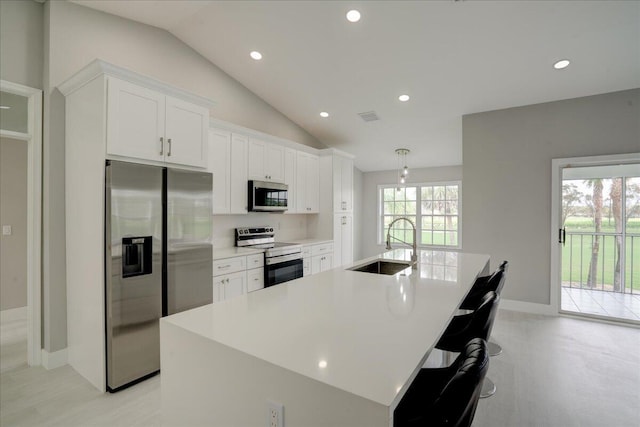 kitchen featuring sink, a center island with sink, white cabinets, and appliances with stainless steel finishes