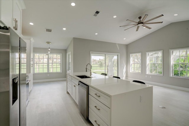 kitchen featuring sink, stainless steel appliances, white cabinetry, and a kitchen island with sink