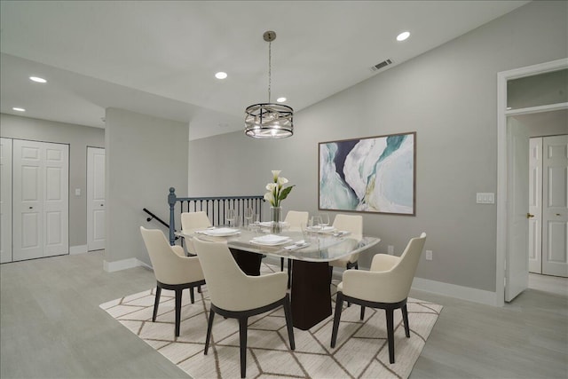 dining room with light hardwood / wood-style flooring and vaulted ceiling