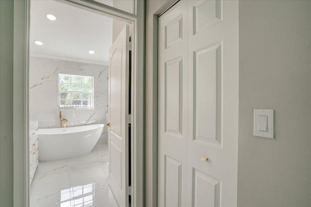 bathroom featuring ornamental molding and a bathing tub