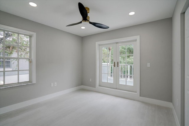 spare room with light hardwood / wood-style flooring, ceiling fan, and french doors