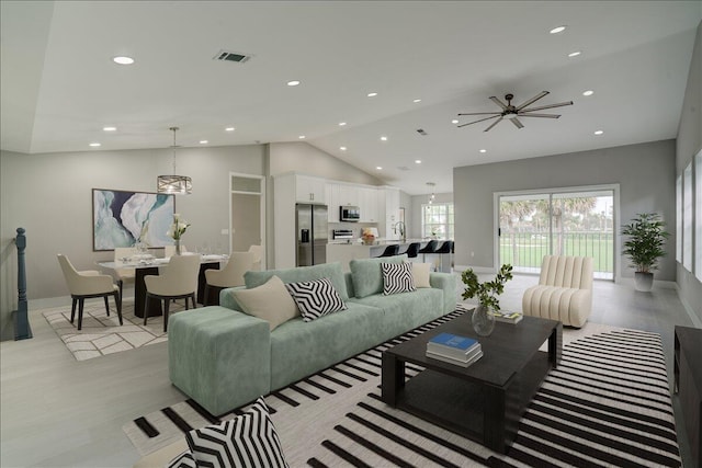 living room with light hardwood / wood-style flooring and vaulted ceiling