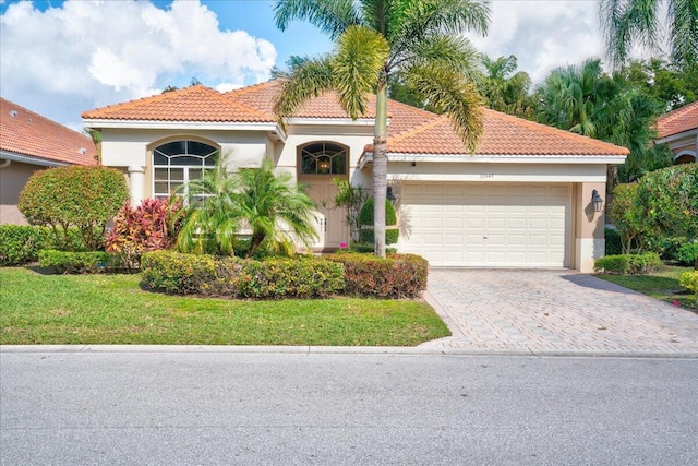 mediterranean / spanish home with a front yard and a garage