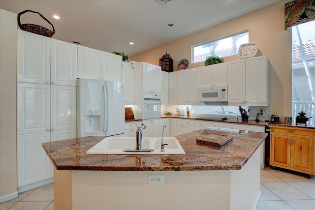 kitchen featuring white cabinetry, sink, white appliances, and an island with sink