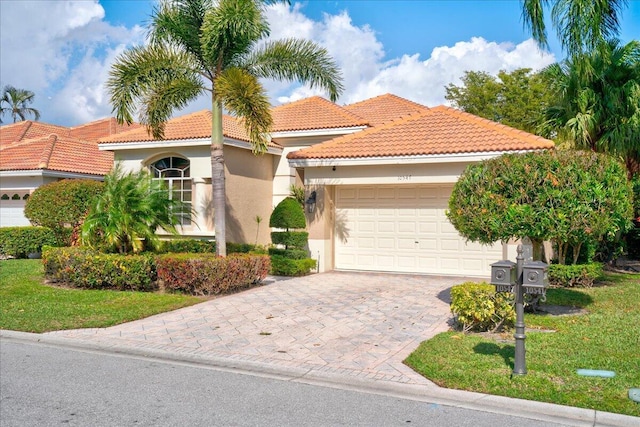 mediterranean / spanish house featuring a garage and a front yard