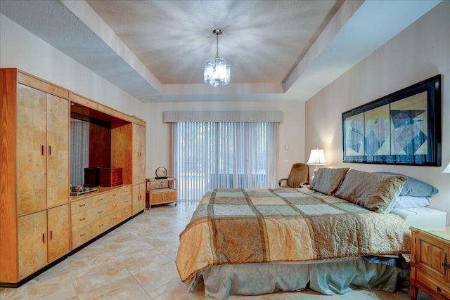 bedroom with a chandelier and a raised ceiling